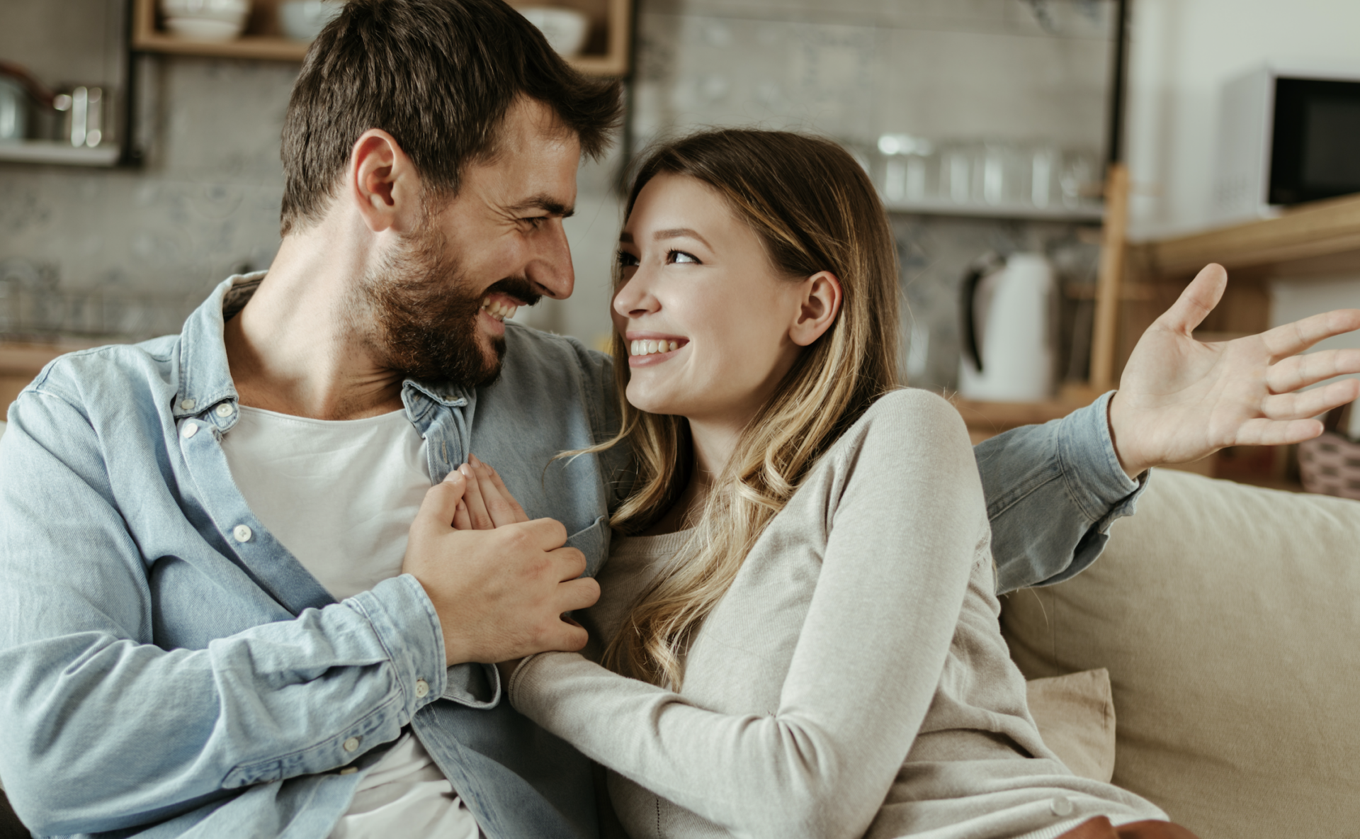 couple smiling talking on couch